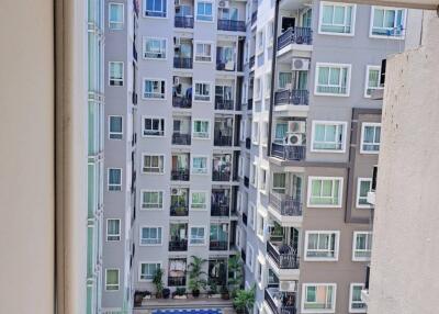 View from a balcony overlooking a residential building with a swimming pool