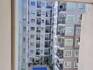 View from a balcony overlooking a residential building with a swimming pool