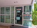 Entrance of a commercial building with glass doors and informational signs