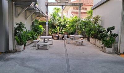 Outdoor common area with benches and greenery in a residential setting