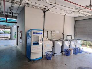 Common laundry room with washing machines and baskets in a residential building