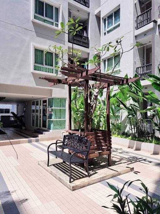 Cozy seating area with bench and pergola in the outdoor communal space of an apartment complex