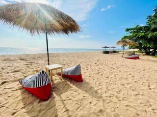 Beachfront property view with lounge chairs and umbrella