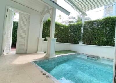 Elegant private pool with columned pergola in a residential patio