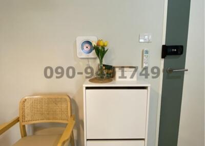 Modern entryway with white storage cabinet, decorative flowers, and elegant door