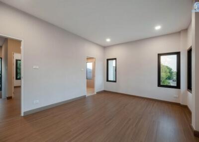 Spacious unfurnished bedroom with hardwood flooring and ample natural light