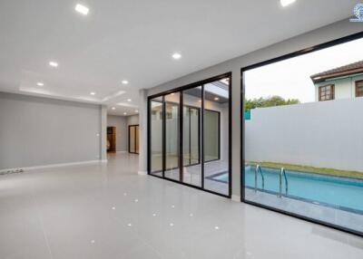 Spacious and modern living room with large glass doors leading to the pool area