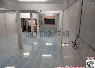 Spacious empty interior space with light blue tiled flooring and white walls