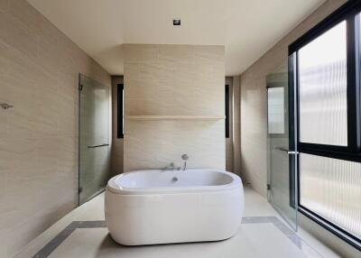 Spacious modern bathroom with freestanding bathtub and separate shower