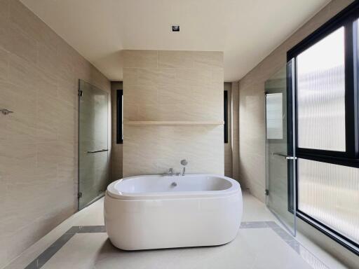 Spacious modern bathroom with freestanding bathtub and separate shower