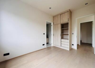 Spacious bedroom with built-in wooden wardrobe and modern flooring