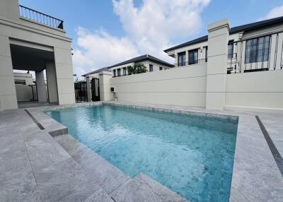 Luxurious private swimming pool with clear blue water in the outdoor area of a modern residential property, showcasing the exterior elegance and leisure amenities