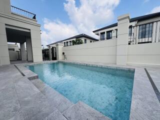 Luxurious private swimming pool with clear blue water in the outdoor area of a modern residential property, showcasing the exterior elegance and leisure amenities