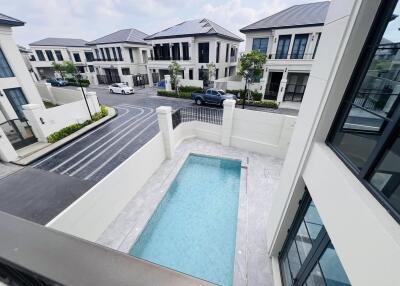View from balcony overlooking a private pool and the street in a residential area