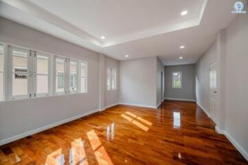Spacious living room with hardwood floors and abundant natural light