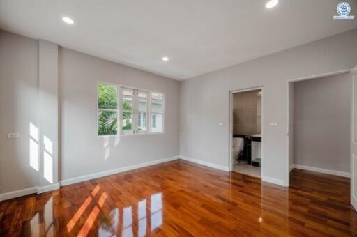 Spacious bedroom with polished hardwood floors and natural light