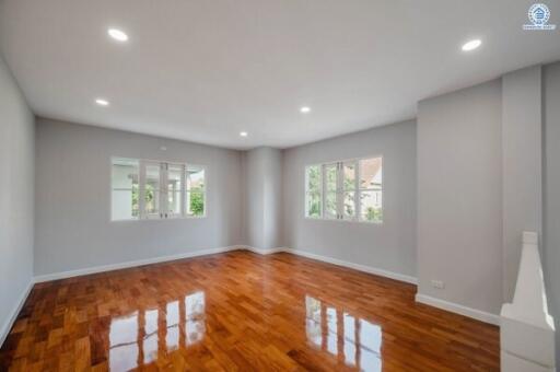 Spacious empty living room with hardwood floors and ample natural light