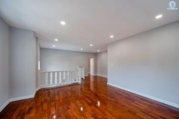 Spacious and well-lit empty room with hardwood floors and white walls