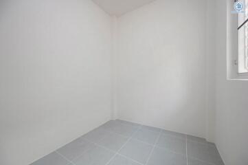 Empty interior space with white walls and tiled flooring