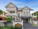 Elegant two-story residential house with a balcony and garage