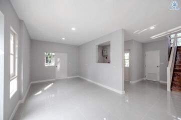 Bright and spacious empty living room with glossy white flooring and multiple windows