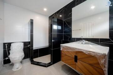 Modern bathroom with elegant black and white tiles and wooden vanity