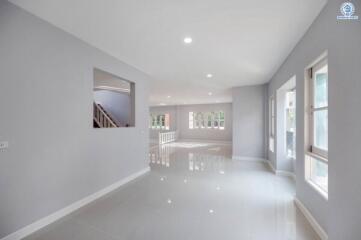 Spacious and well-lit living room with glossy floor and multiple windows