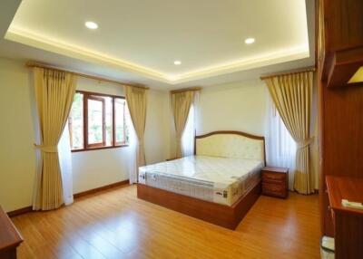 Bright and spacious bedroom with wooden floors and large windows