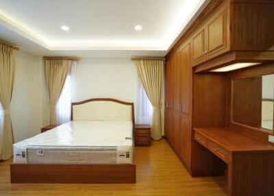 Spacious bedroom with large bed and wooden furniture