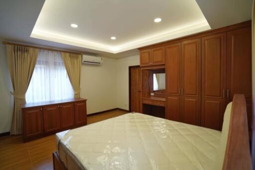 Spacious bedroom with wooden built-in wardrobes and modern lighting