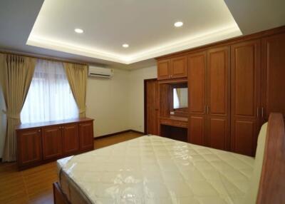 Spacious bedroom with wooden built-in wardrobes and modern lighting