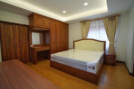 Spacious bedroom with wooden furnishings and built-in wardrobe