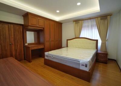 Spacious bedroom with wooden furnishings and built-in wardrobe