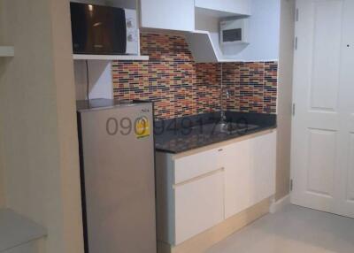 Modern kitchen with microwave and mosaic backsplash