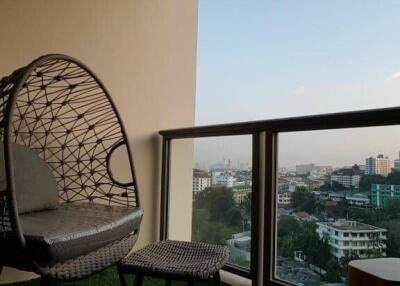 Cozy balcony with a hanging egg chair enjoying a city view