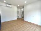 Spacious unfurnished bedroom with hardwood flooring and built-in closet