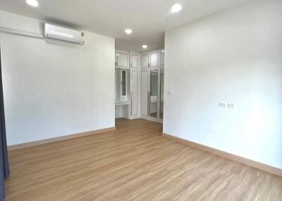 Spacious unfurnished bedroom with hardwood flooring and built-in closet