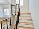 Modern staircase with wooden steps and black metallic railing