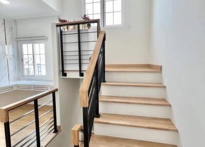 Modern staircase with wooden steps and black metallic railing
