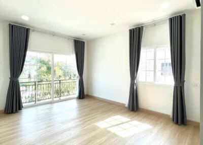 Spacious and bright bedroom with large windows and hardwood floors