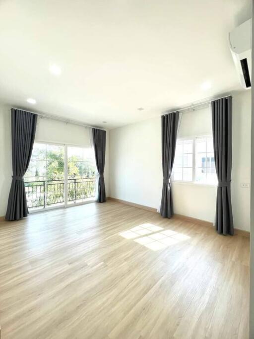 Spacious and bright bedroom with large windows and hardwood floors