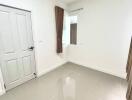 Bright empty bedroom with tiled floor and white walls