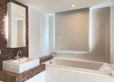 Modern bathroom with mosaic tile backsplash and a large bathtub