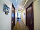 Brightly lit hallway in a residential property with multiple wooden doors and carpeted floor