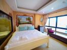 Spacious bedroom with a large bed, artistic mural, and ample natural light