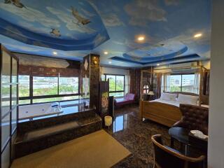 Spacious bedroom with sky-painted ceiling and jacuzzi