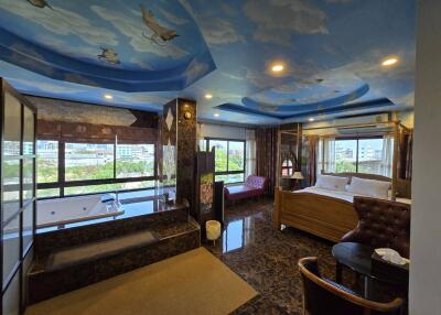 Spacious bedroom with sky-painted ceiling and jacuzzi
