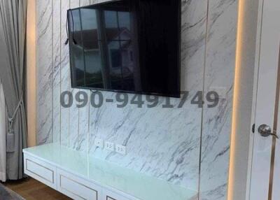 Modern living room with marble wall and mounted television