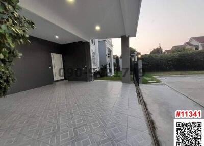 Paved driveway leading to modern house with garage under twilight sky