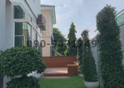 Front yard of a modern residential house with manicured lawn and shrubs